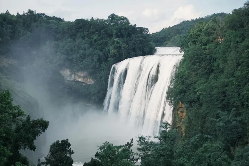 A wide waterfall in a green forest