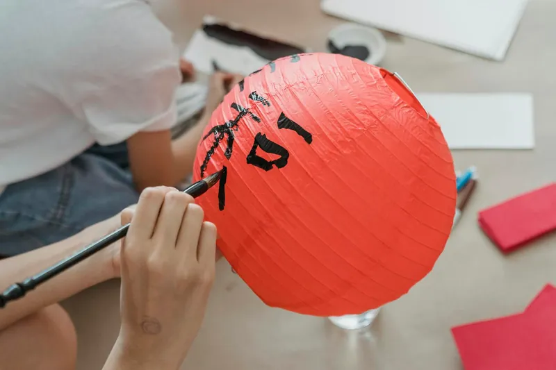 Person Holding a Red Paper Lantern